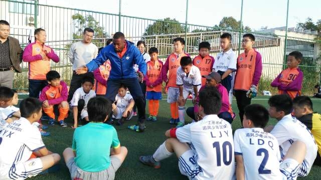 路易斯教中国孩子踢足球