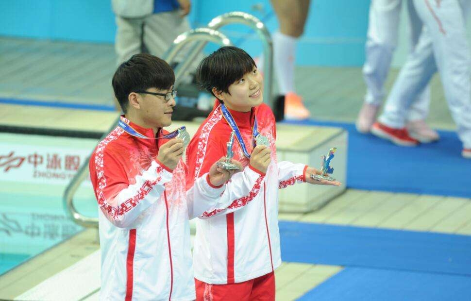 我校学生许丹露（女）与教练在领奖台上