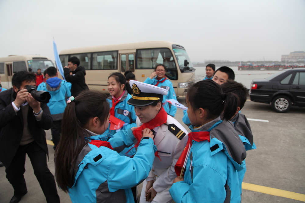 少先队员为罗捷老师佩戴红领巾