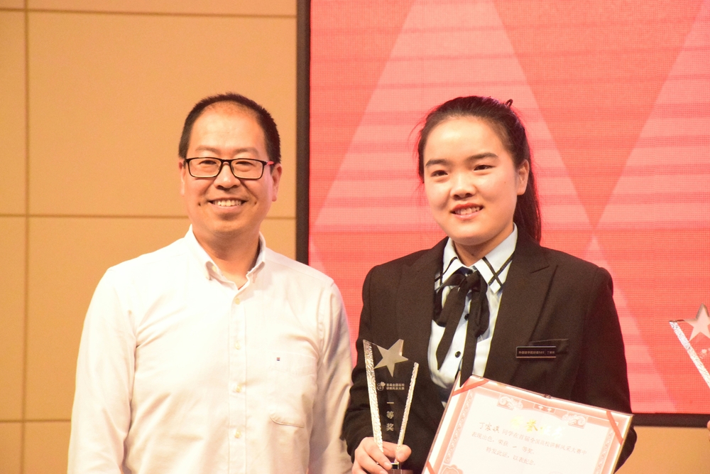 浙江大学离退休工作处处长，关心下一代委员会副主任王庆文为丁宸琪颁奖