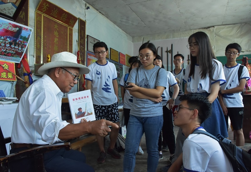 施秉县苗学会会长潘家相向队员们讲解《苗族理词读本》