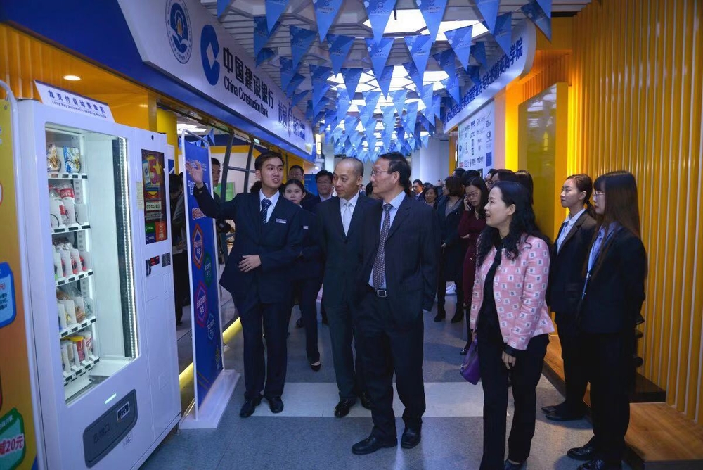 学生行长向嘉宾介绍校园e银行内各种智能设备