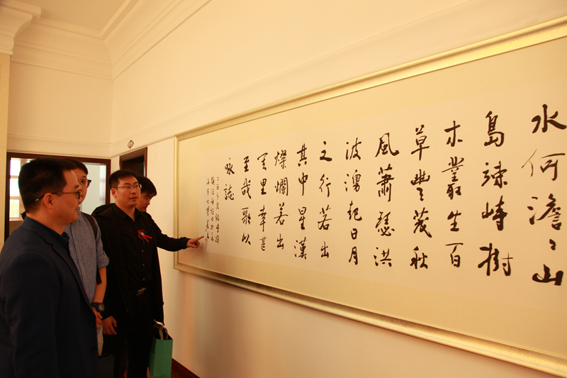 校友们欣赏徐悲鸿艺术学院院长乐震文教授捐赠的书法作品