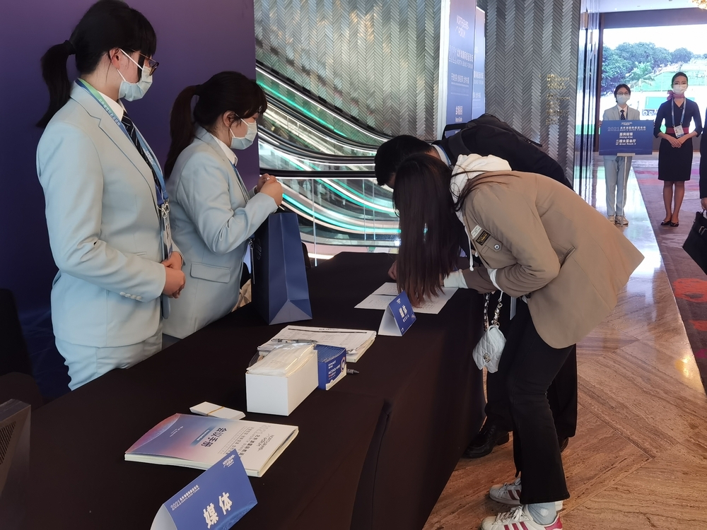 签到处志愿者帮助来宾登记信息