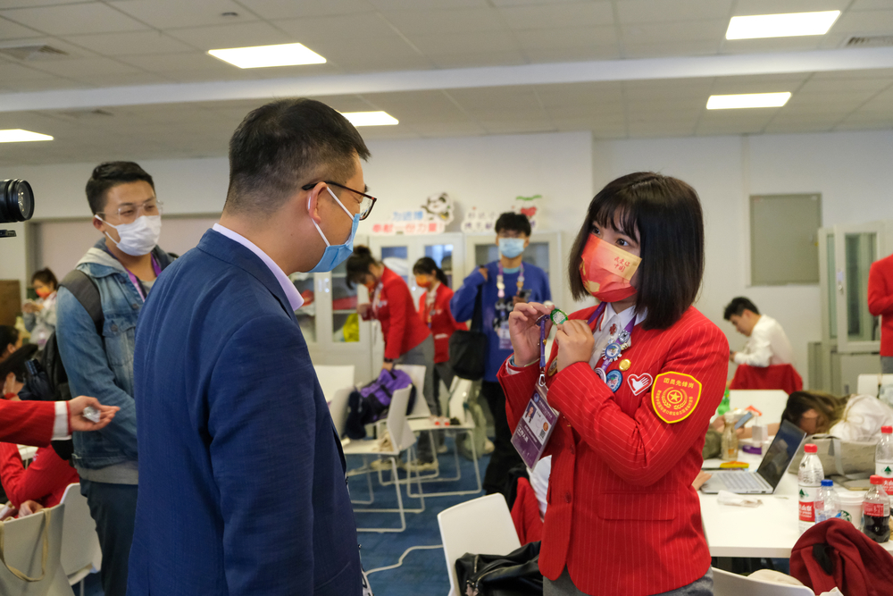 志愿者向李志鹏副校长介绍徽章文化